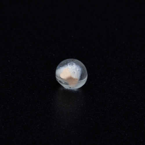 TX-1, spironolactone fragment embedded in resin sphere, approximately 4-5mm in diameter; pre-launch photo; credit, Adriana Knouf